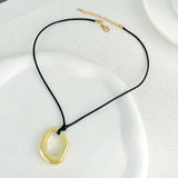 Pendentif ovale abstrait en or et collier ajustable en corde noire