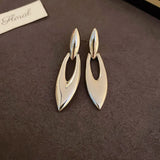 Boucles d'oreilles argentées de style antique avec motif abstrait en forme de feuille