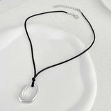 Pendentif abstrait en argent et collier en corde noire