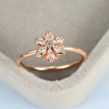 Bague en or rose avec motif floral et cristaux étincelants