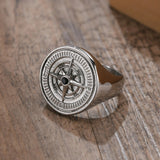 Bague argentée avec motif roue de boussole et pierre foncée