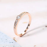 Bague pavée étincelante avec pierre ronde centrale en or rose