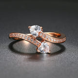 Bague en or rose avec deux cristaux en forme de cœur et bande pavée de cristaux