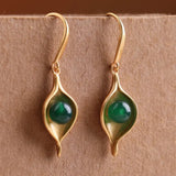 Boucles d'oreilles pendantes classiques en or ovale avec pierres précieuses vertes et feuilles