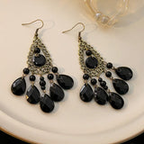 Boucles d'oreilles pendantes à pompons noirs en forme de plume de paon