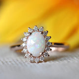 Bague vintage en or rose ovale avec opale et bordure en cristal rayonnant