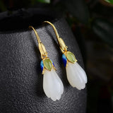 Boucles d'oreilles pendantes classiques en or et fleurs blanches avec pierres vertes