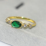 Bague vintage en or avec pierre précieuse ovale verte et côtés étincelants