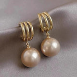 Boucles d'oreilles pendantes vintage en or avec griffes et perles champagne