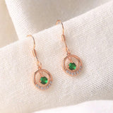 Boucles d'oreilles pendantes classiques en or rose avec pierre verte et cristal