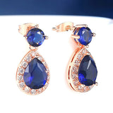 Boucles d'oreilles pendantes en or rose avec pierres précieuses bleues et blanches