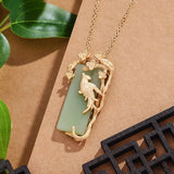 Collier pendentif oiseau doré, gemme verte et branche de fleur de pie