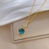 Collier vintage avec pendentif planète et papillon en or