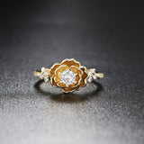Bague classique en or avec fleur centrale sertie d'une pierre précieuse et cristaux sur les côtés