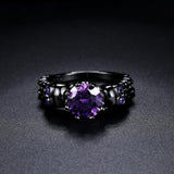 Bague vintage noire ronde avec pierre précieuse violette et motif complexe