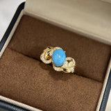 Bague rétro en or et pierre bleue avec motif feuille