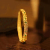 Bracelet rigide de style ethnique en or avec pierres précieuses vertes et motif floral