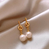 Boucles d'oreilles pendantes en or et perles blanches