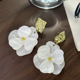 Boucles d'oreilles pendantes vintage en or et fleurs blanches