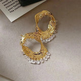 Boucles d'oreilles classiques en or avec pendentifs en cristal et motif sculpté en forme de vague