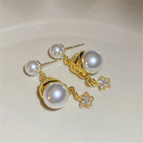 Boucles d'oreilles en or de style antique avec perle et pendentif étoile scintillante