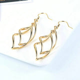Boucles d'oreilles pendantes vintage en or avec courbes géométriques complexes