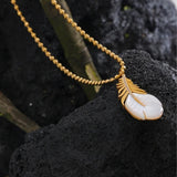 Collier vintage avec pendentif en forme de coquillage et feuilles dorées