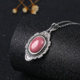Collier pendentif en argent orné de pierres précieuses