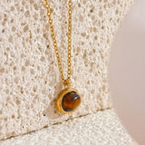 Collier pendentif rond en or avec pierre brune